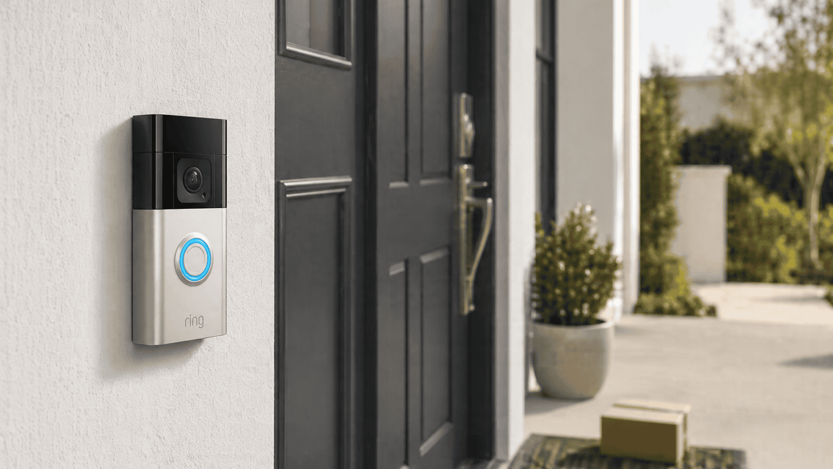 Ring Video Doorbell 2nd Gen mounted beside a modern front door with a package on the doorstep.